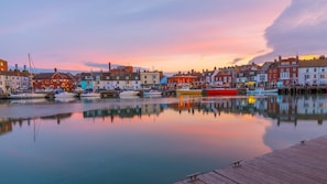 A waterfront with colorful buildings and boats docked at a pier. - House - Sleeps 6, Pet Friendly & Courtyard (Weymouth)