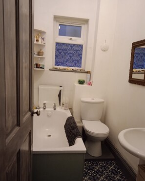 Un baño con bañera, inodoro y lavamanos.