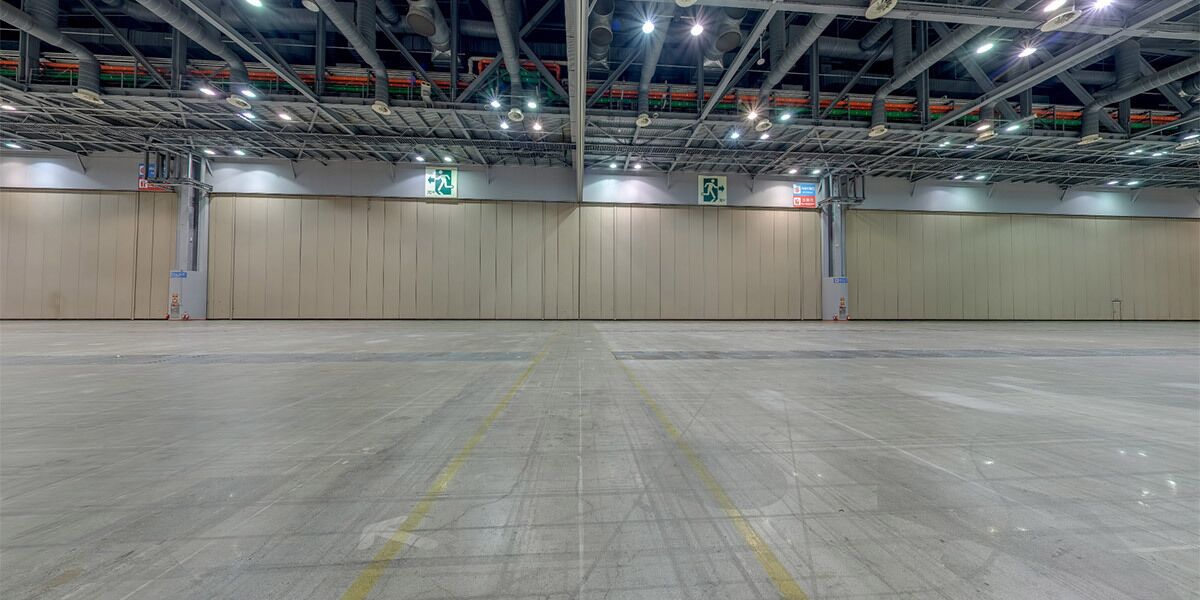 A spacious indoor parking area with concrete floors and metal beams.