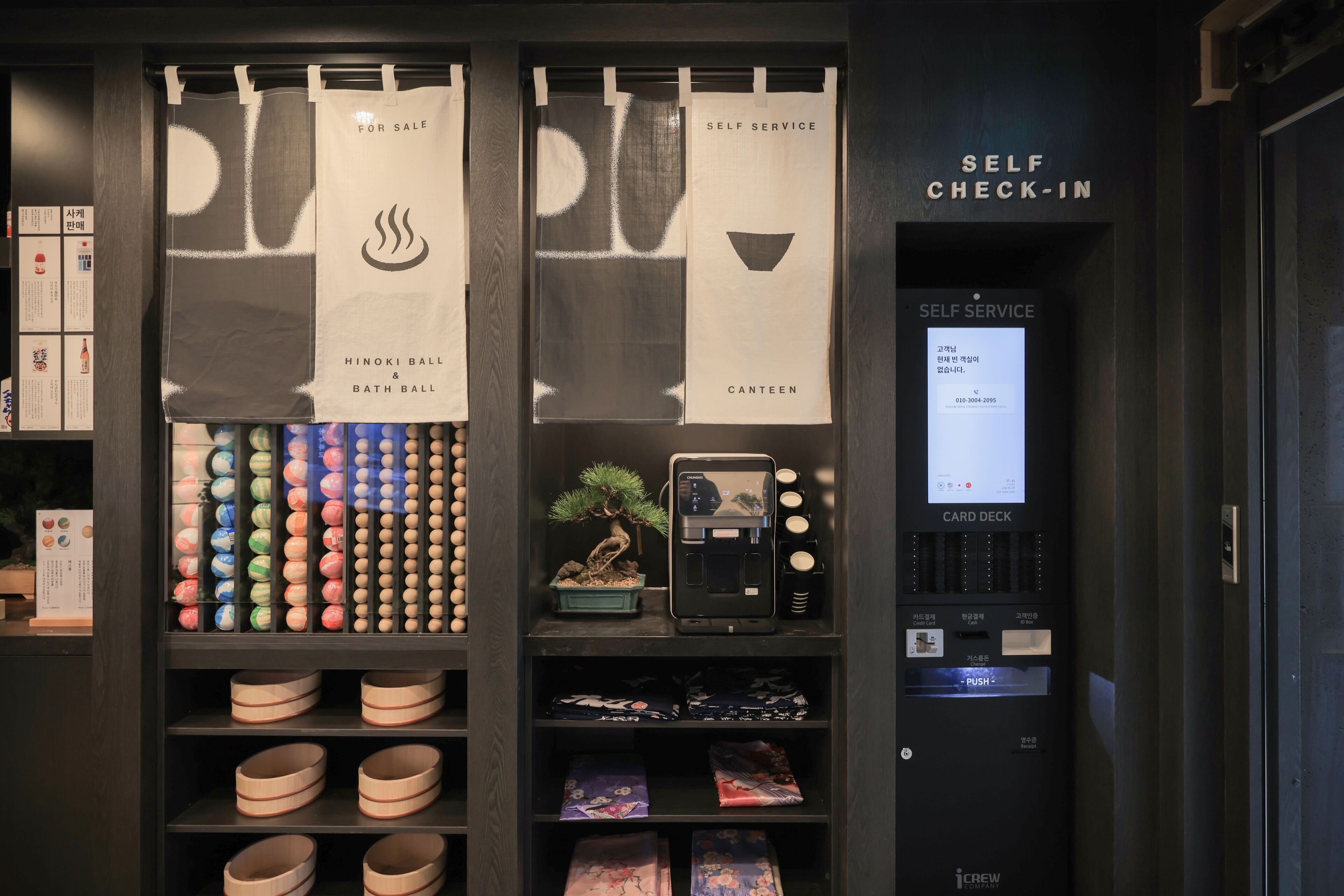A self-service check-in kiosk and a display of bath and canteen products.