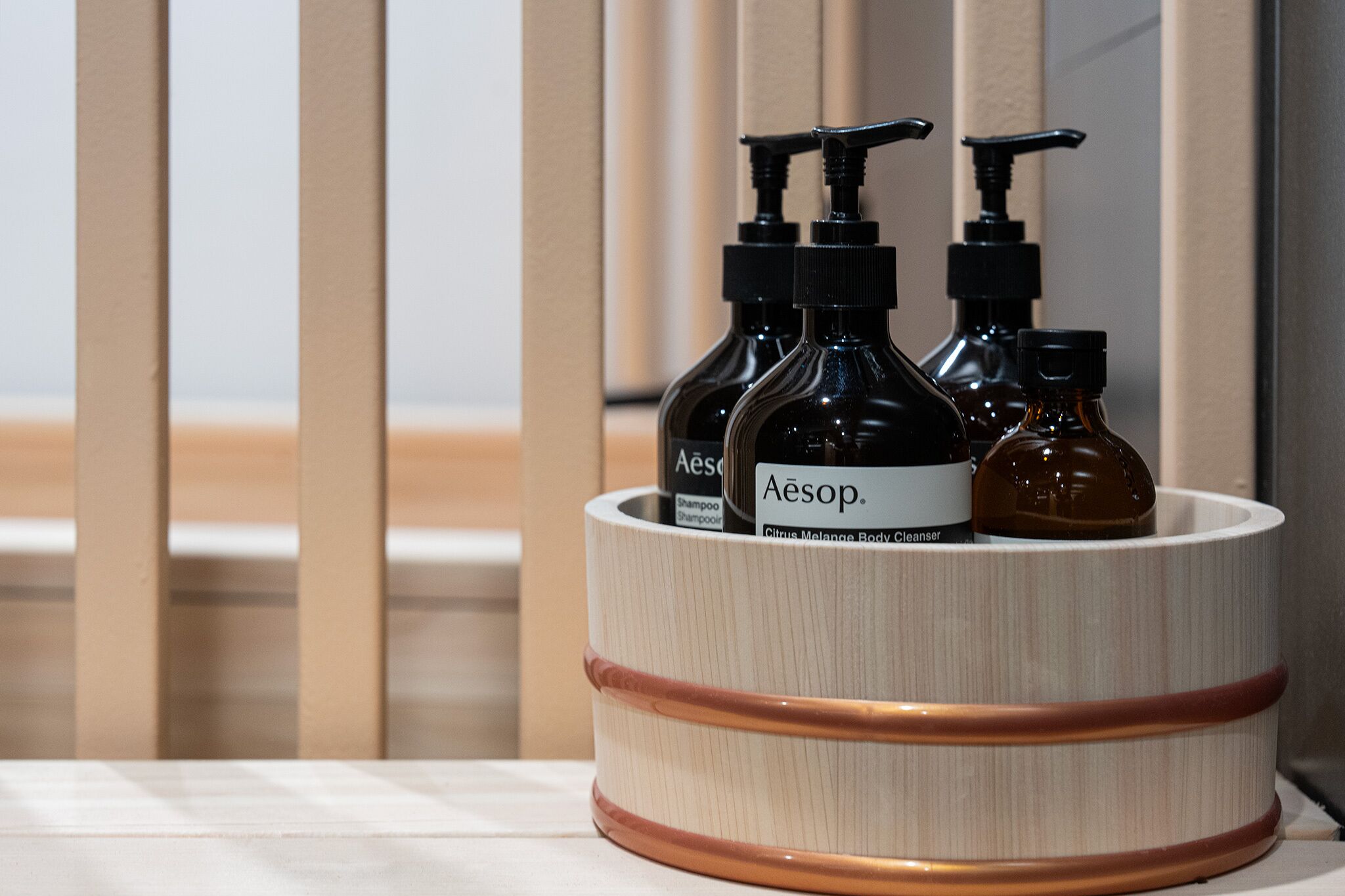 En träskål med tre flaskor hudvårdsprodukter från märket Aesop.