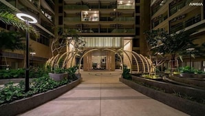 A hotel entrance with a central archway, surrounded by greenery and a well-lit pathway. - Thuy's Homestay - The Song Vung Tau (Ho Chi Minh City)