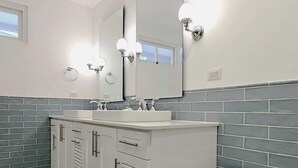 A modern bathroom with a white vanity, a toilet, and a large mirror. - w* | Amazing 1BR w/ Balcony  & AC in San Felipe (Panamá)
