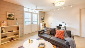 A modern living room with a grey sofa, a white coffee table, and a bookshelf. - w* | Upgraded 1BR w/ Balcony in Panama (Panamá)