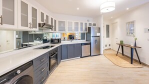 Une cuisine moderne avec des meubles gris, des appareils en acier inoxydable et un îlot central.