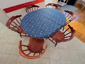 A round table with a blue patterned tablecloth, surrounded by four wooden chairs with curved backs. - Loft Vista Mare (Zadar)