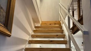 A wooden staircase with white railings and a white wall. - Bordeaux 45 (Cape Town)