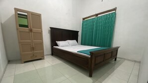 Ein Schlafzimmer mit Bett, Kleiderschrank und einem fenster mit Vorhängen.