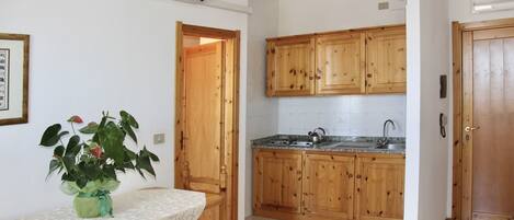 Cocina con armarios de madera, encimera de granito y un fregadero.