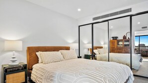 A modern hotel room with a large bed, a nightstand with a lamp, and a mirror reflecting the room. - Cityscape at The Elliott in the Heart of Hobart (Hobart)