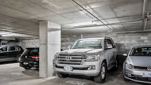 A parking garage with concrete pillars and a gray floor, featuring three parked SUVs. - Cityscape at The Elliott in the Heart of Hobart (Hobart)