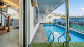 A modern interior with a pool, a staircase, and a view of the outdoors. - Namhae Eagless Poolvilla Pension (Namhae)