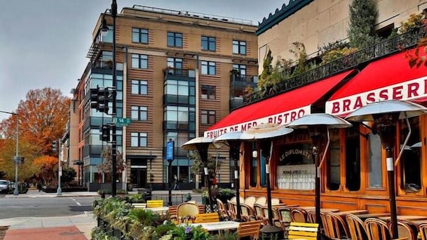 Un restaurante con terraza y toldo rojo.