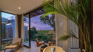Un salon moderne doté d’une porte vitrée donnant sur un balcon qui offre une vue imprenable sur un paysage magnifique.