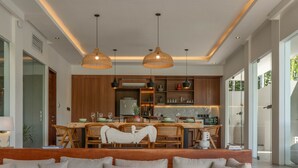 Un salon moderne avec un grand canapé, une table basse ronde et un ventilateur de plafond.