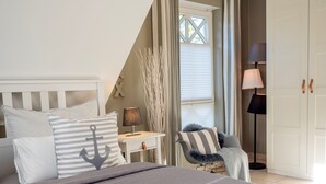 Une chambre à coucher avec un lit, une chaise, un bureau et une lampe.