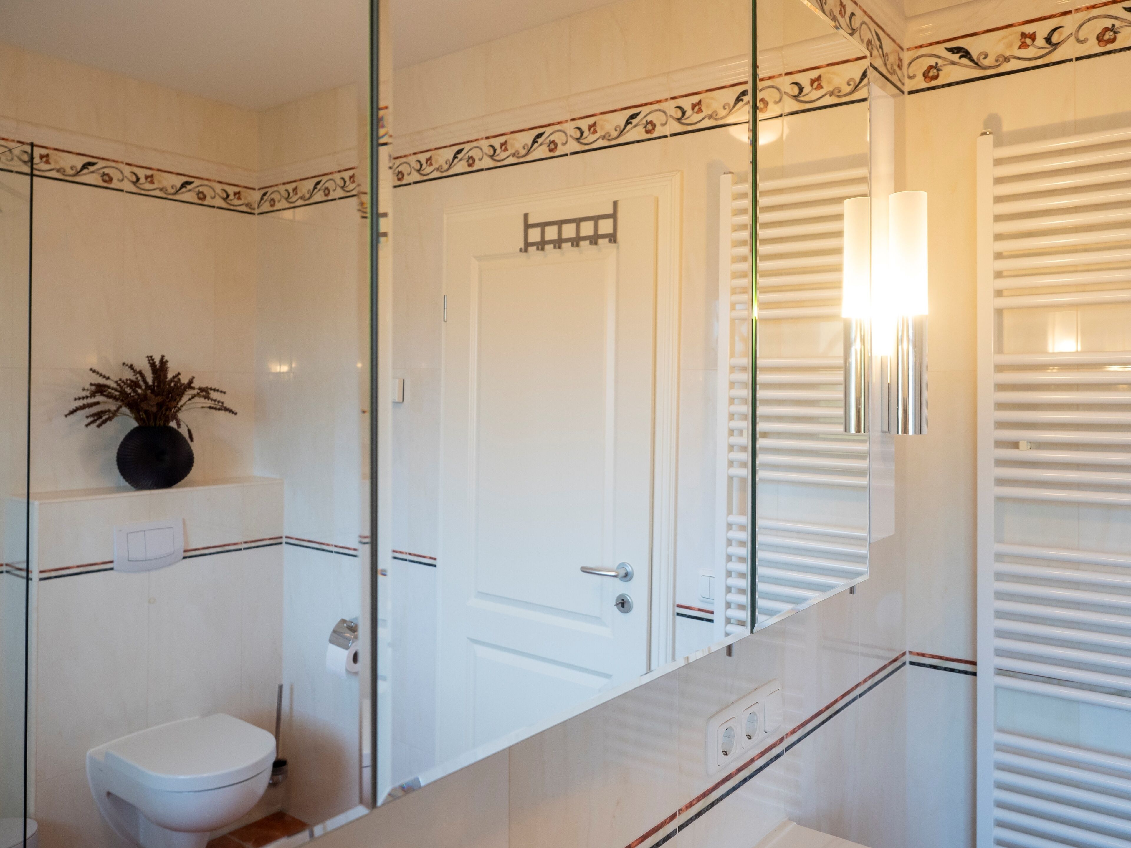 A bathroom with a toilet, a mirror, and a towel rack.