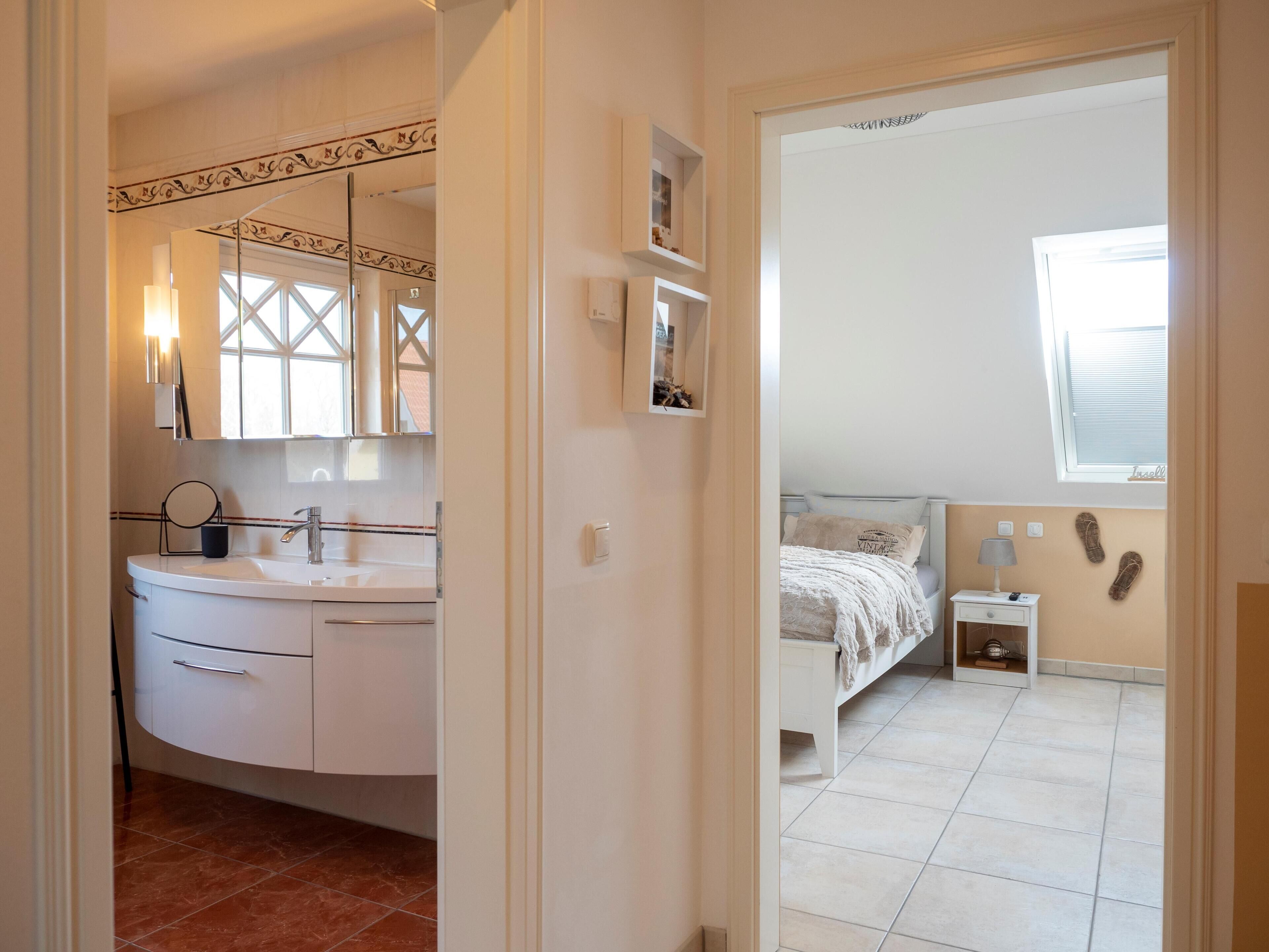 A bedroom with a bed, nightstand, and a window.