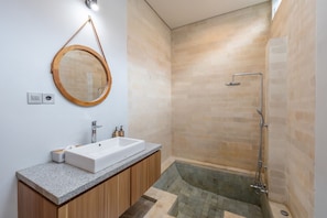 Villa | Badkamer | Een bad/douchecombinatie, een haardroger, handdoeken, zeep