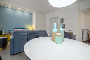 A modern living room with a round white table, a sofa set, and decorative vases.