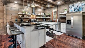 A modern kitchen with a central island, stainless steel appliances, and wooden accents. - 🏡 Luxury Smoky Mountain Retreat | Mega Spa, Game Room & Stunning Views (Cosby)