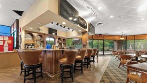 Zona de bar con taburetes, una barra y un letrero que dice 'LEDGASOME'.