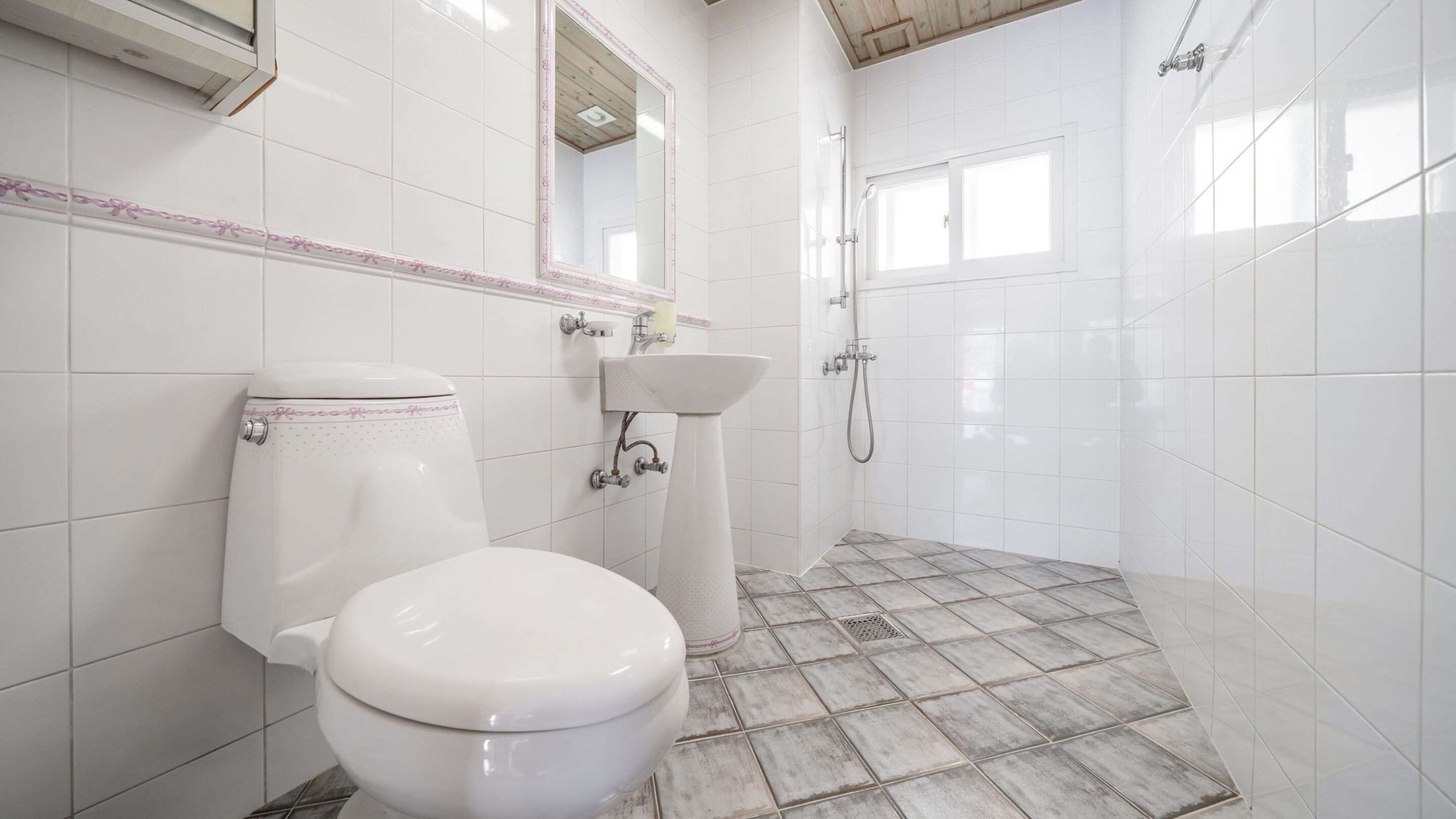 A bathroom with a toilet, sink, and shower.