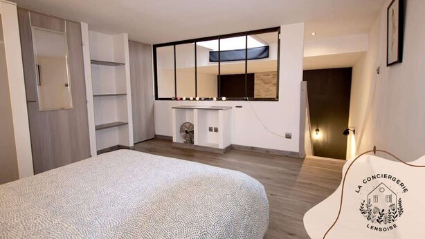 Een moderne slaapkamer met een groot bed, een inbouwkast en een opvallend plafond met een ingedompelde zone.