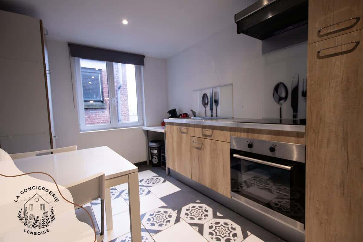 Een moderne keuken met een raam, een eettafel en een logo op de muur.