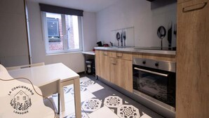 Een moderne keuken met een raam, een eettafel en een logo op de muur.