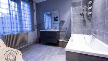 Une salle de bain moderne équipée d’une baignoire, d’une douche et d’un meuble-lavabo avec un miroir.