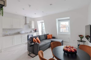A modern apartment with a kitchen, dining area, and living room.