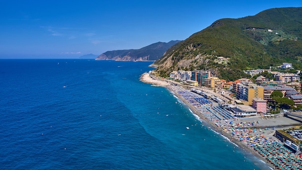 A coastal town with a beach lined with colorful umbrellas and buildings. - Peaceful Apartment With Terrace In Deiva Marina (Deiva Marina)