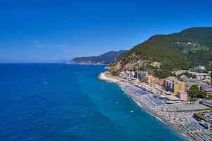 Un pueblo costero con una playa bordeada de sombrillas coloridas y edificios.