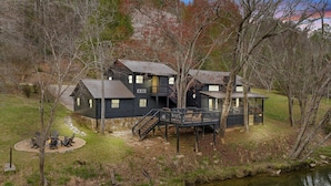 A cabin with a deck, a fire pit, and a small outdoor seating area.