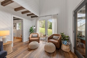 Relax in this inviting living space with a sloped ceiling, leather armchairs, and a cozy table.