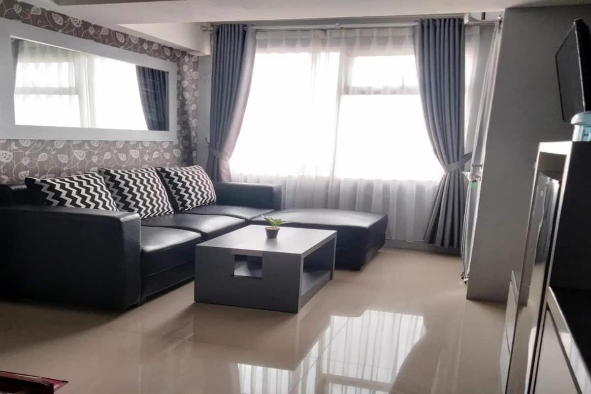 Ein modernes Wohnzimmer mit einer Couch, einem Couchtisch und einem Fernseher.