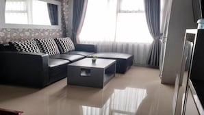 A modern living room with a sofa, a coffee table, and a TV.