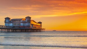 A waterfront hotel with a pier extending into the sea, featuring multiple levels and a prominent tower. - Dungarvon House B&B (Weston-super-Mare)
