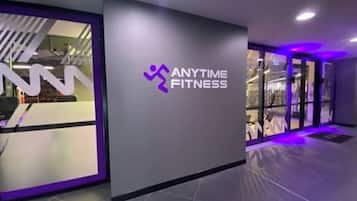 Une salle de sport avec un logo sur le mur et un espace d’accueil.