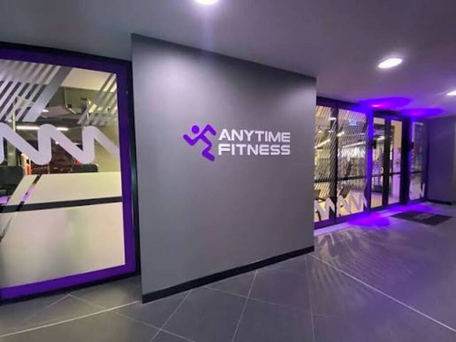 Une salle de sport avec un logo sur le mur et un espace d’accueil.