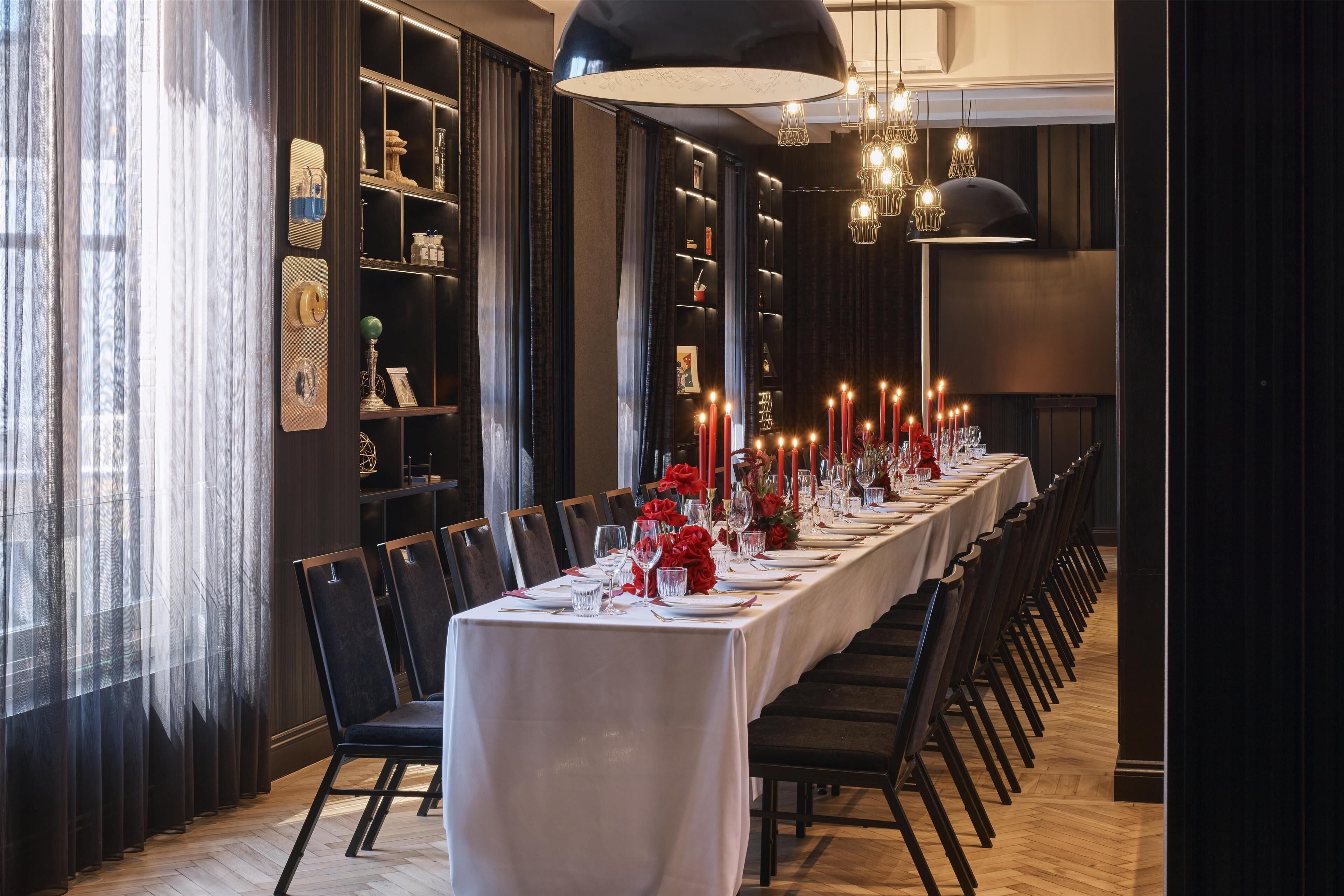 A long dining table set for a formal event, with chairs aligned on both sides.