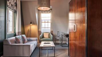Ein modernes Wohnzimmer mit Sofa, Sessel, Couchtisch und Schrank.