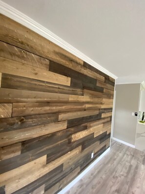 Una habitación con paneles de madera en la pared y una puerta que da a otro espacio.