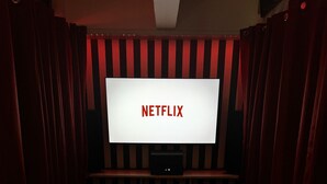 A theater-style room with a large screen displaying "NETFLIX" and a sofa in the foreground. - Cinematic Experience in fully renovated apartment near Montmartre - Paris (Paris)