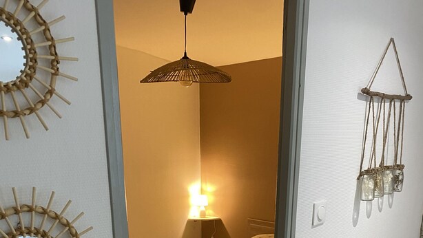 Une chambre avec un lit, une lampe et des miroirs décoratifs sur les murs.