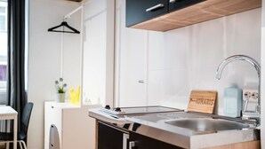 Une cuisine moderne équipée d’une cuisinière intégrée, d’un évier et d’une enseigne en bois portant le nom « JOMARIS ».