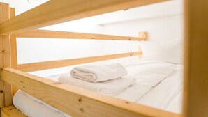 A bunk bed with a wooden frame and white bedding. - Cosy Box at Boxhagener Platz (Berlin)