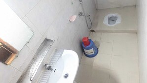 A small bathroom with a sink, toilet, and shower. - Hotel Hoque Tower International (Chittagong)