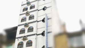 A multi-story building with several arched windows and air conditioning units. - Hotel Hoque Tower International (Chittagong)